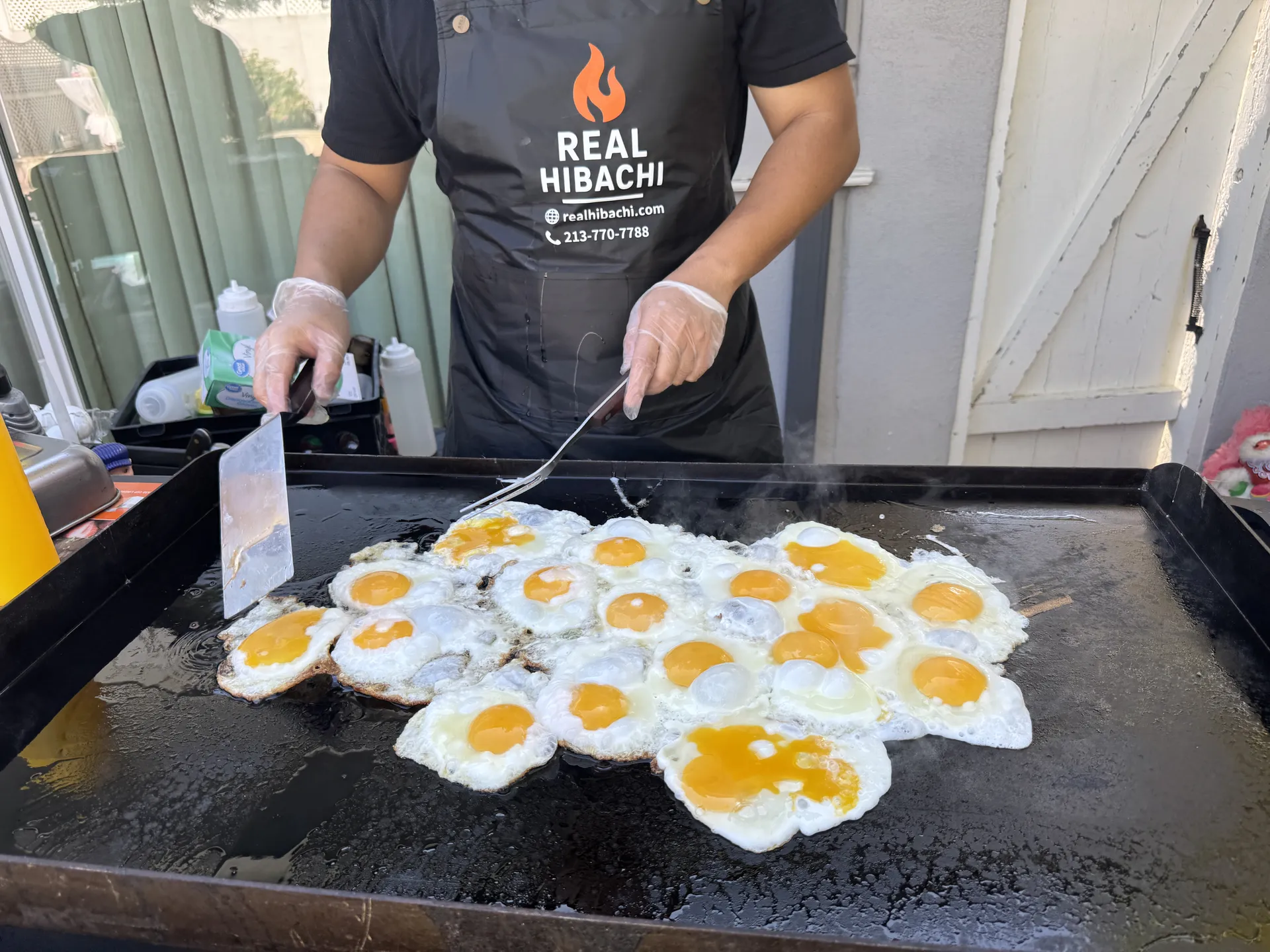 Real Hibachi chef cooking fresh eggs on the griddle at an Orange County family event